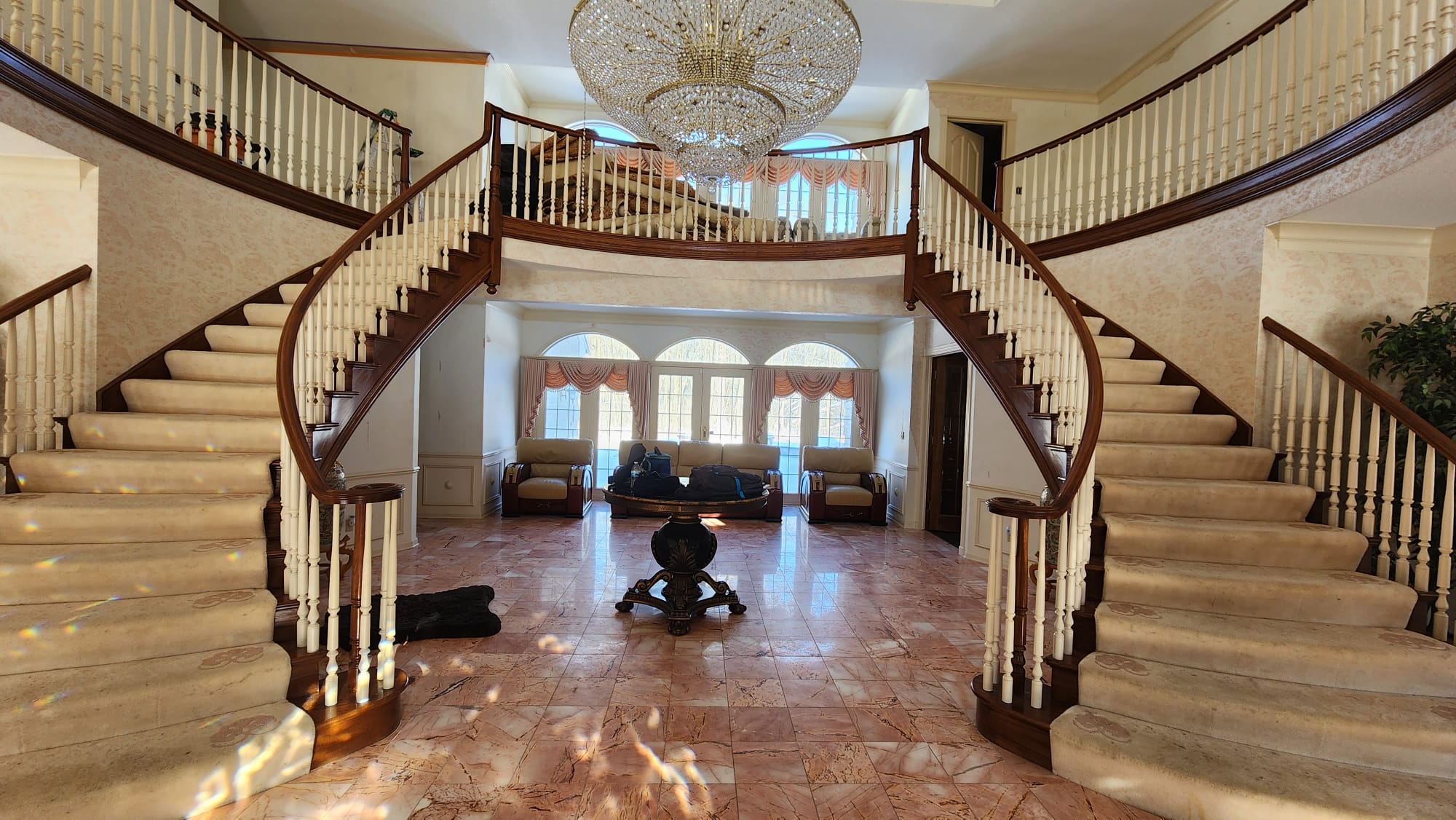 Grand double curved staircase with crystal chandelier